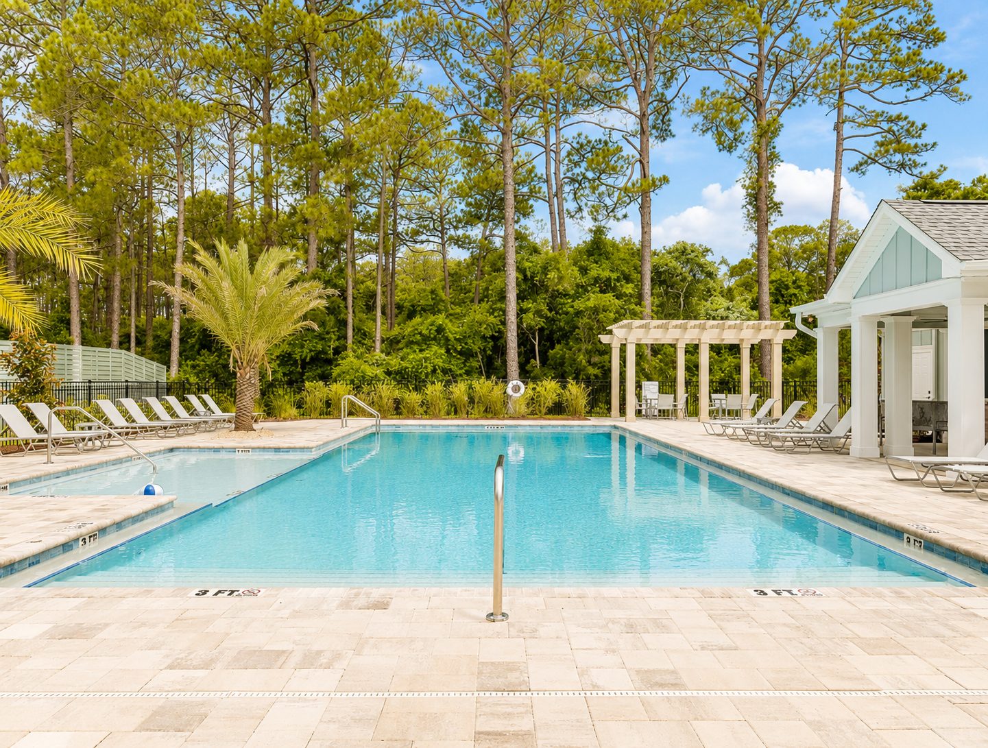 The community pool surrounded by tall pines